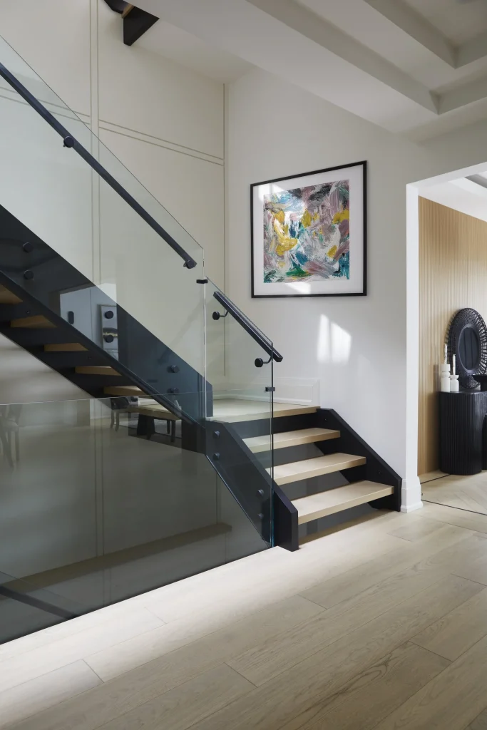 Modern staircase with glass panels.‎