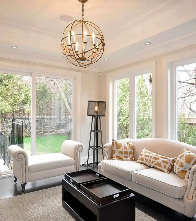 Bright sunroom with large windows and greenery.‎